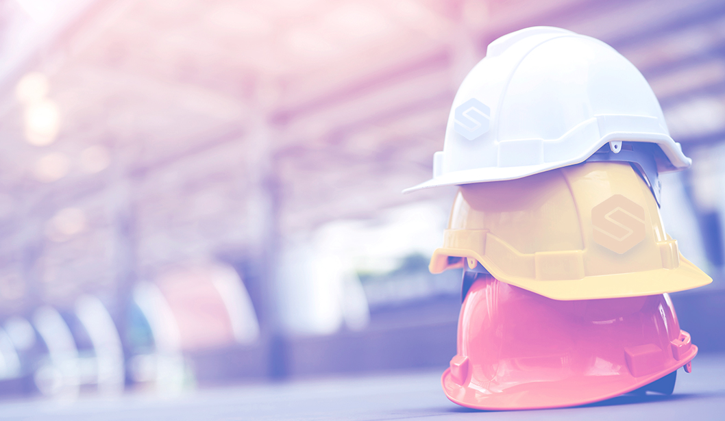 Cascos de seguridad apilados en un entorno industrial.