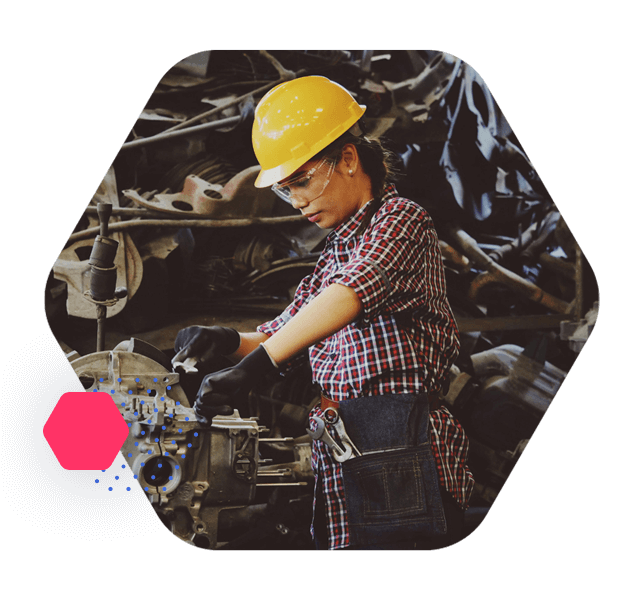 Profesional con casco y gafas de protección trabajando en un entorno industrial.